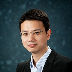 A person wearing glasses and a suit  Description automatically generated